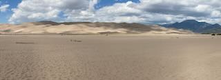 The Great Sand Dunes National Park. Photo taken from the parking lot, looking north across the expanse of the sandy base. The Sand Dunes are in the background of the photo.